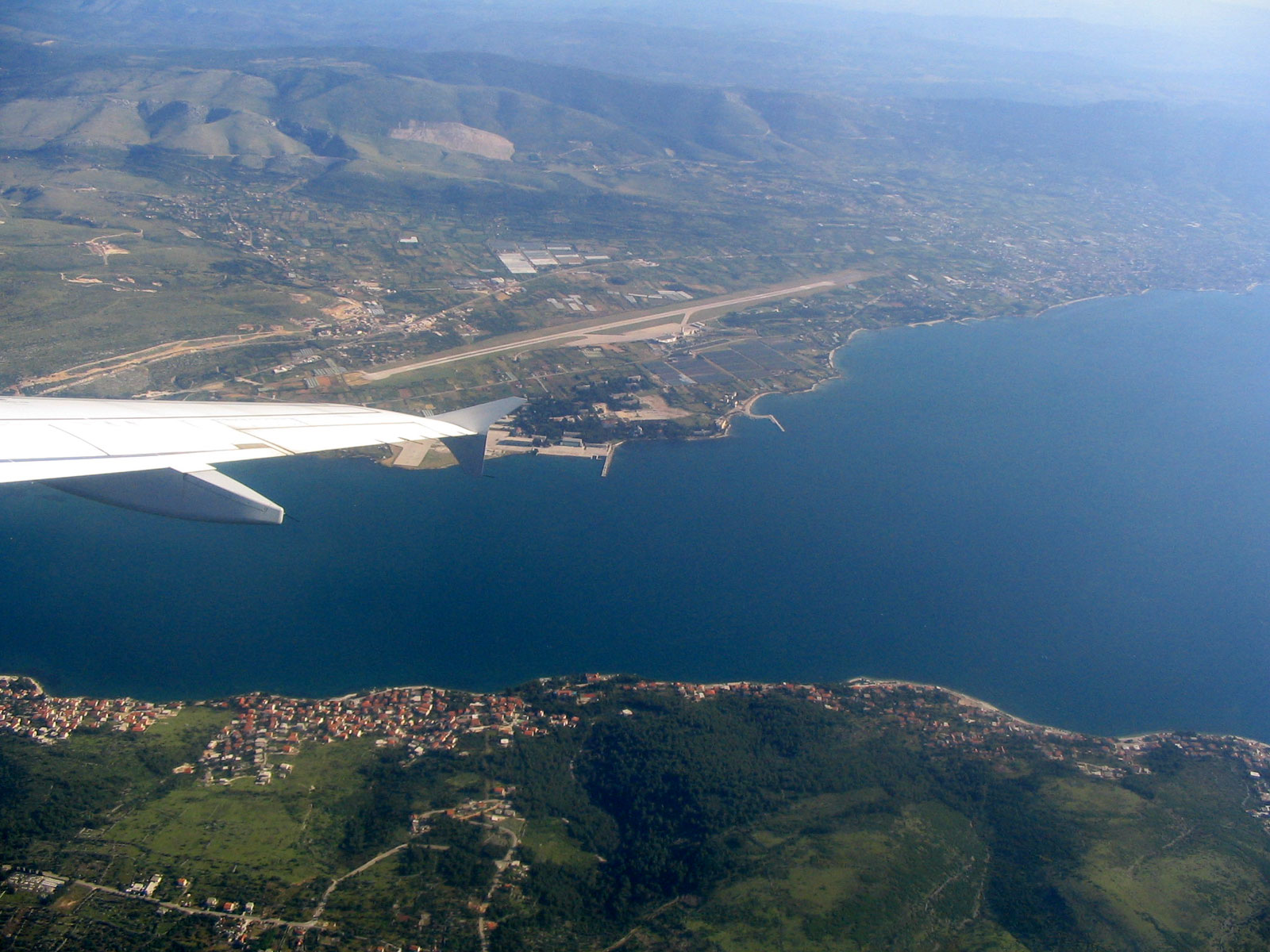 A wing view aerial shot of Split Airport from a departing aircraft