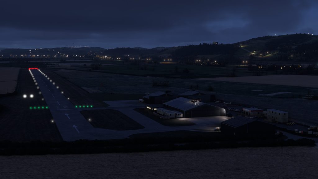 Burning Blue Design's Welshpool airport for MSFS 2020 and MSFS 2024, in sim aerial view of the runway and apron at night.