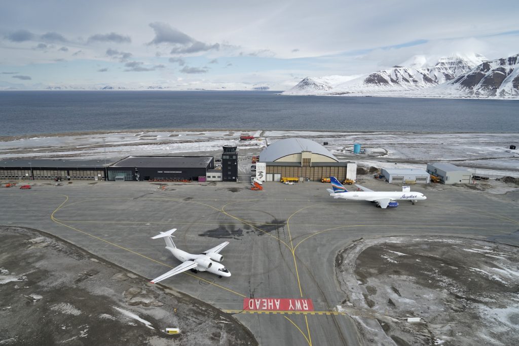 Real life picture of Svalbard's airport' apron featuring a parked Boeing 757 and a taxying Antonov AN 72 aircraft. 