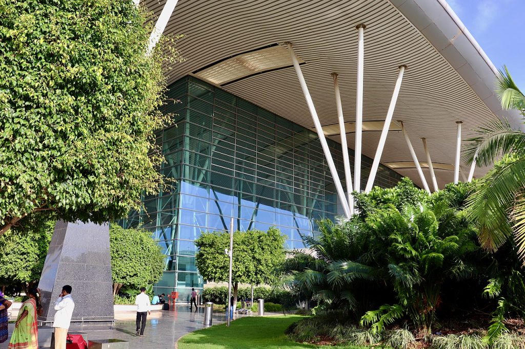 Real life picture of Bengalaru's Real life picture of Bengalaru's Kempegowda International Airport terminal 2 outside, showing lush vegetation and distinctive architectural features