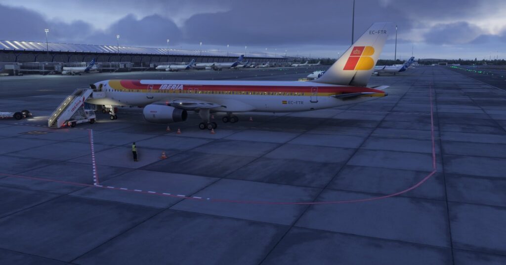 An Iberia BlueBird 757 sits on the ramp, with the tail light on.