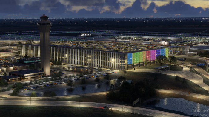 Nighttime view of Kansas City airport terminal and control tower with colorful illuminated facade and runways in the background