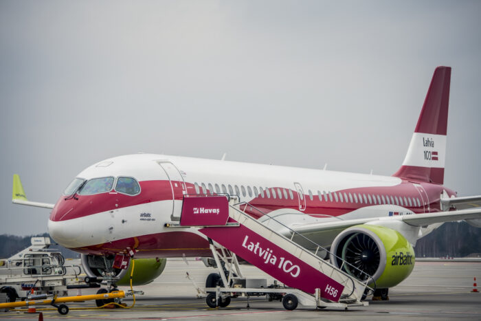 airBaltic Airbus A220-300 in the Latvia 100 special livery parked on the airport apron