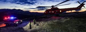 Emergency helicopter flying over a mountain ridge at dusk in MSFS 2024